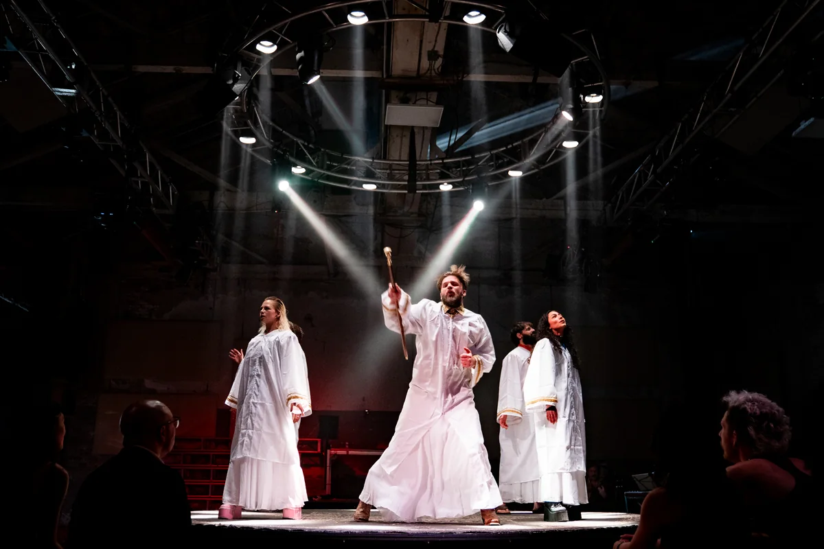 Robed performers in a ring of stage light in The Golden Calf.
